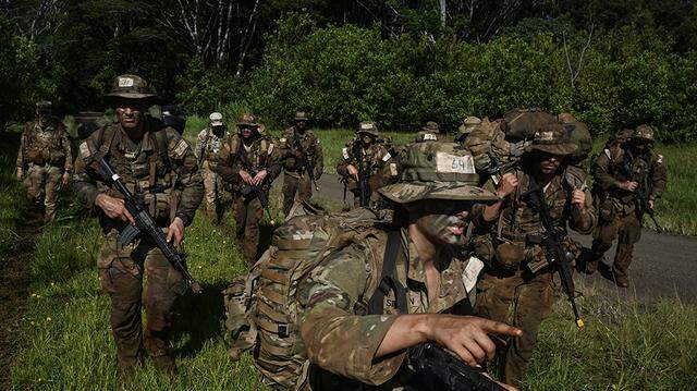 U.S. Army soldiers participate in a 12-day jungle operations training course near Honolulu on Oct. 10, 2024. The government agency that keeps a list of draft-eligible men will begin automatically registering names later this year, abandoning a decades-old requirement that they register themselves.